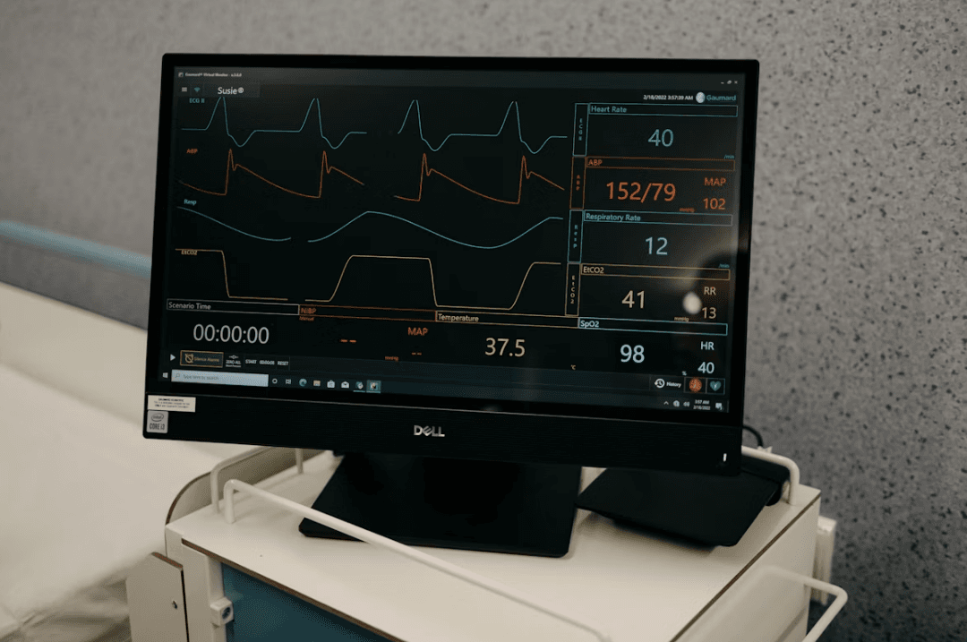 A patient vital-signs monitor displaying heart rate and other readings on medical equipment.